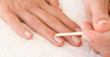 Load image into Gallery viewer, Gently pushing back cuticle with an orangewood stick after applying CND Cuticle Eraser